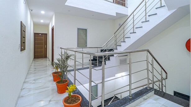 A modern interior with a staircase, potted plants, and a skylight. - Fabhotel Casa (Mohali)