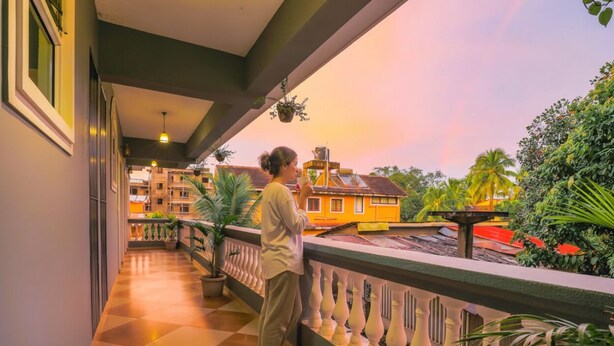 A balcony with a checkered floor, potted plants, and a view of buildings and trees. - Fabhotel Royal Mirage With Pool & Gym - Nr Candolim Beach (Candolim)