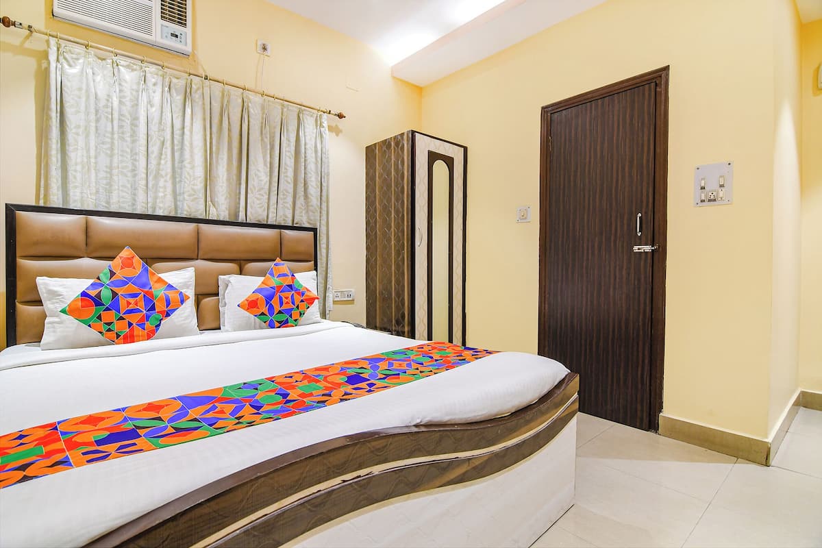 A hotel room with a bed, a wardrobe, and a door.