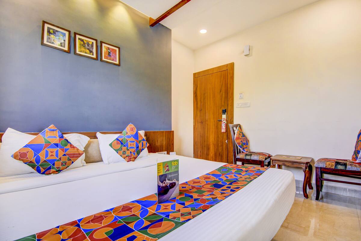 Une chambre d’hôtel avec un grand lit, une porte en bois et une petite table.