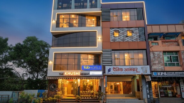 Un hôtel à plusieurs étages, doté d’un design moderne, avec une entrée imposante agrémentée d’un escalier et de plantes en pot.
