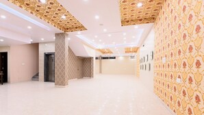 A spacious, well-lit lobby with a patterned wall and a tiled floor. - Fabhotel 7Th Crossing (Jaipur)