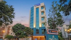 Un hotel moderno con un llamativo letrero que dice 'fob hotels', un letrero de 'Mayfair Tower' y una entrada bien iluminada.