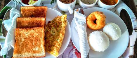A tray with toast, a fried egg, white rice, a donut, and various sauces.