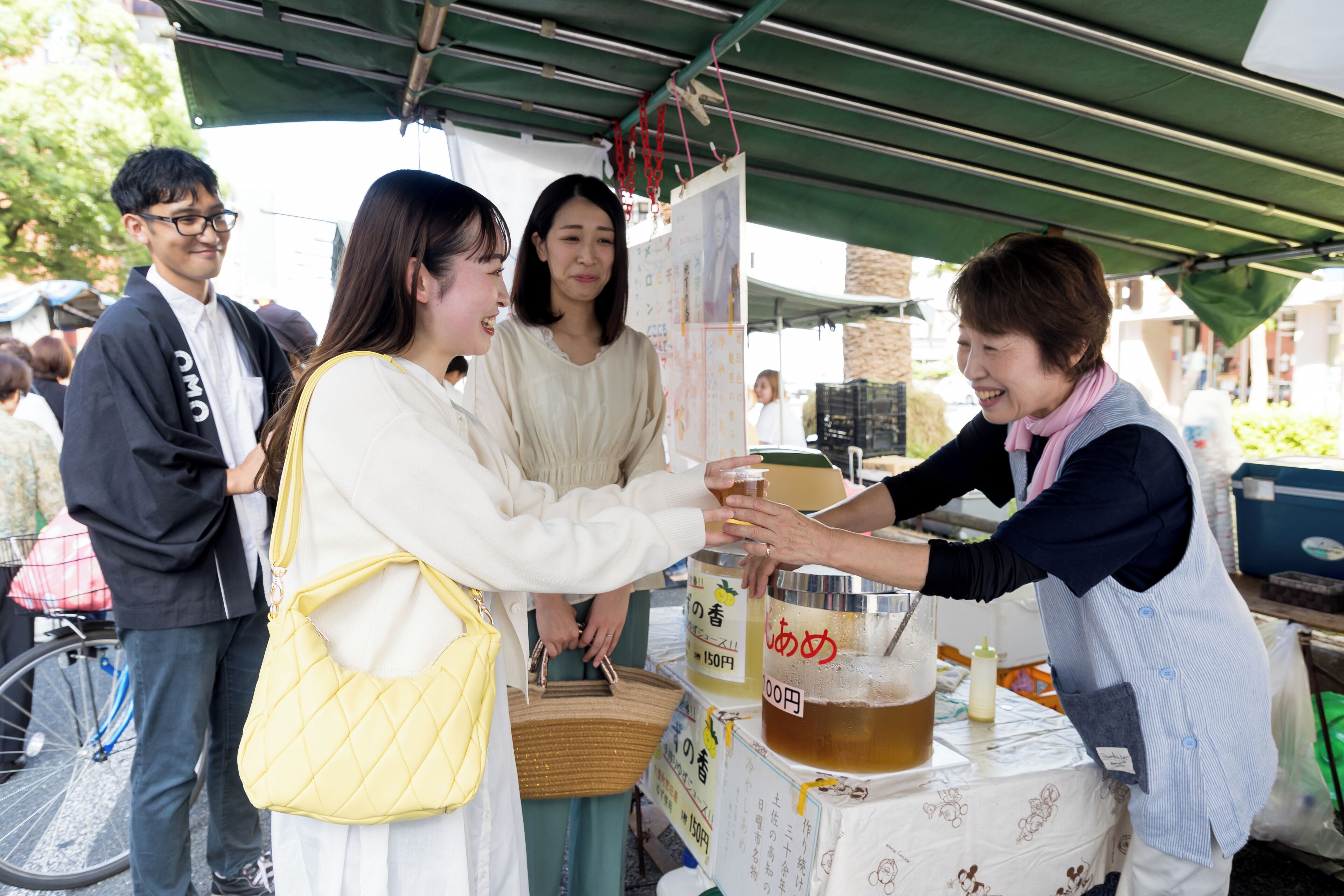 A food stall with a table displaying various food items and a drink dispenser.