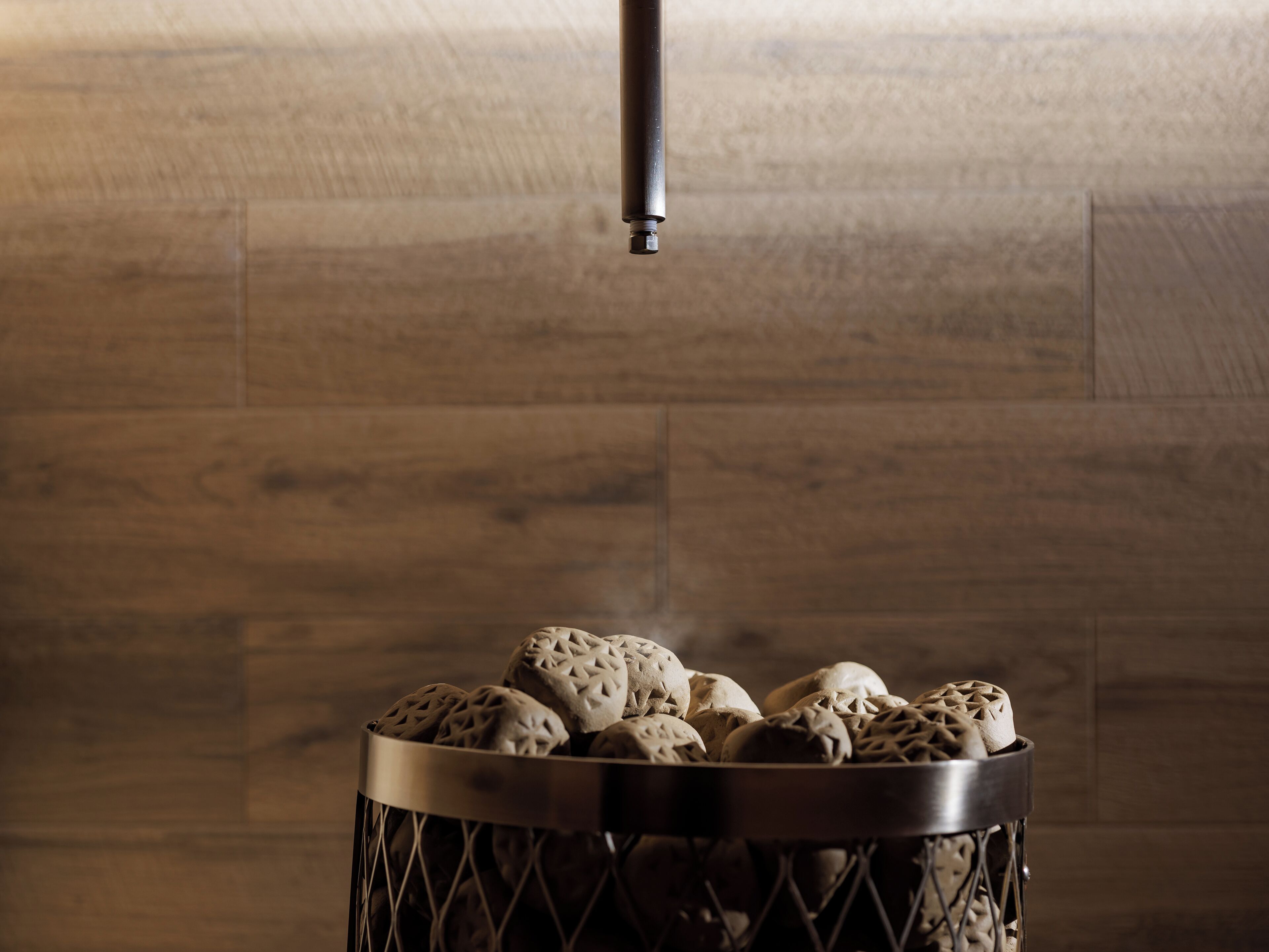 A metal basket filled with intricately designed bread loaves.