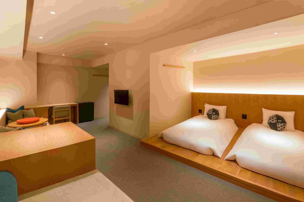 Una habitación de hotel moderna con una cama grande, un escritorio y un área de descanso.