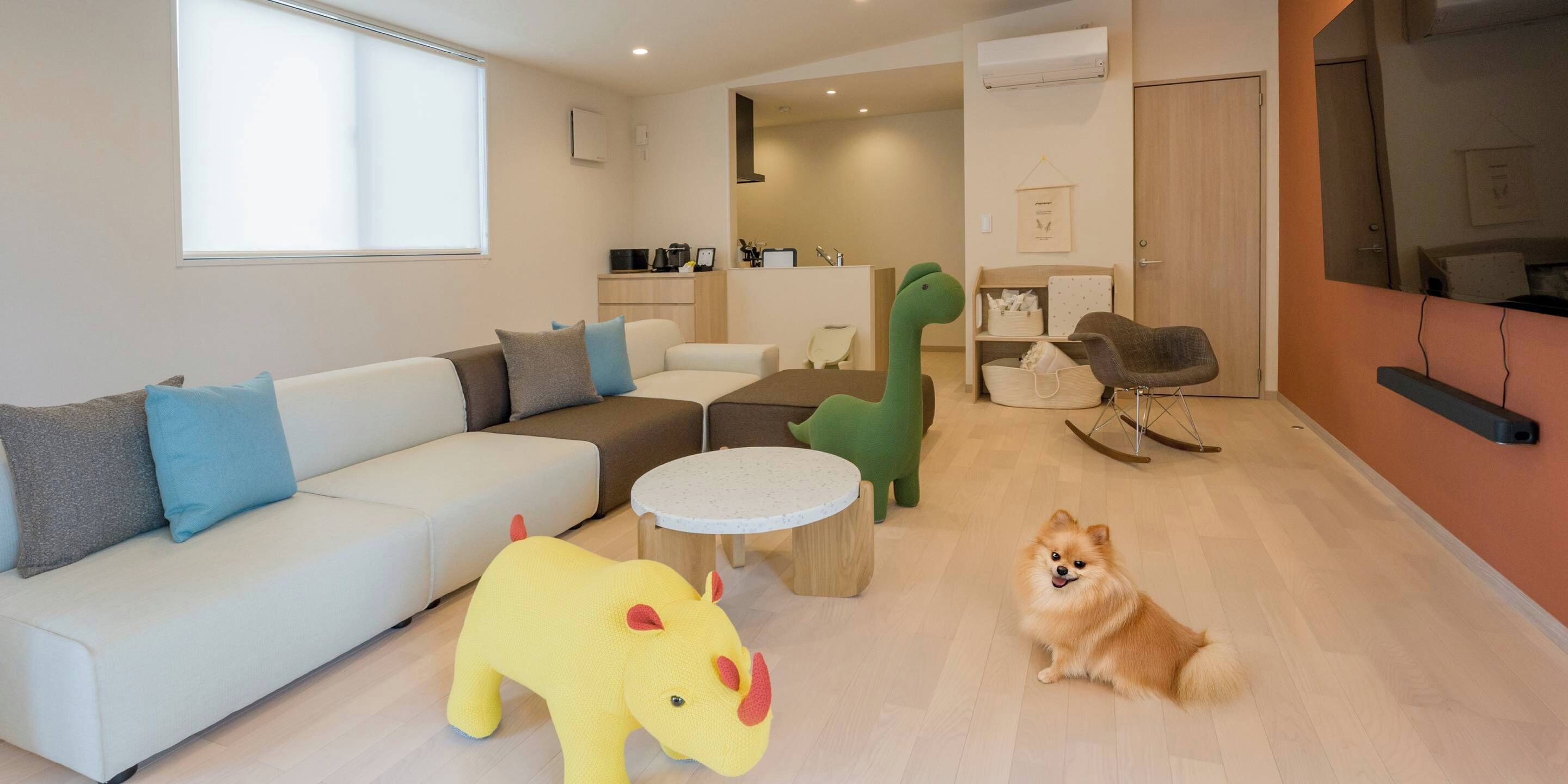 A modern living room with a sofa, a round coffee table, and a small dog.