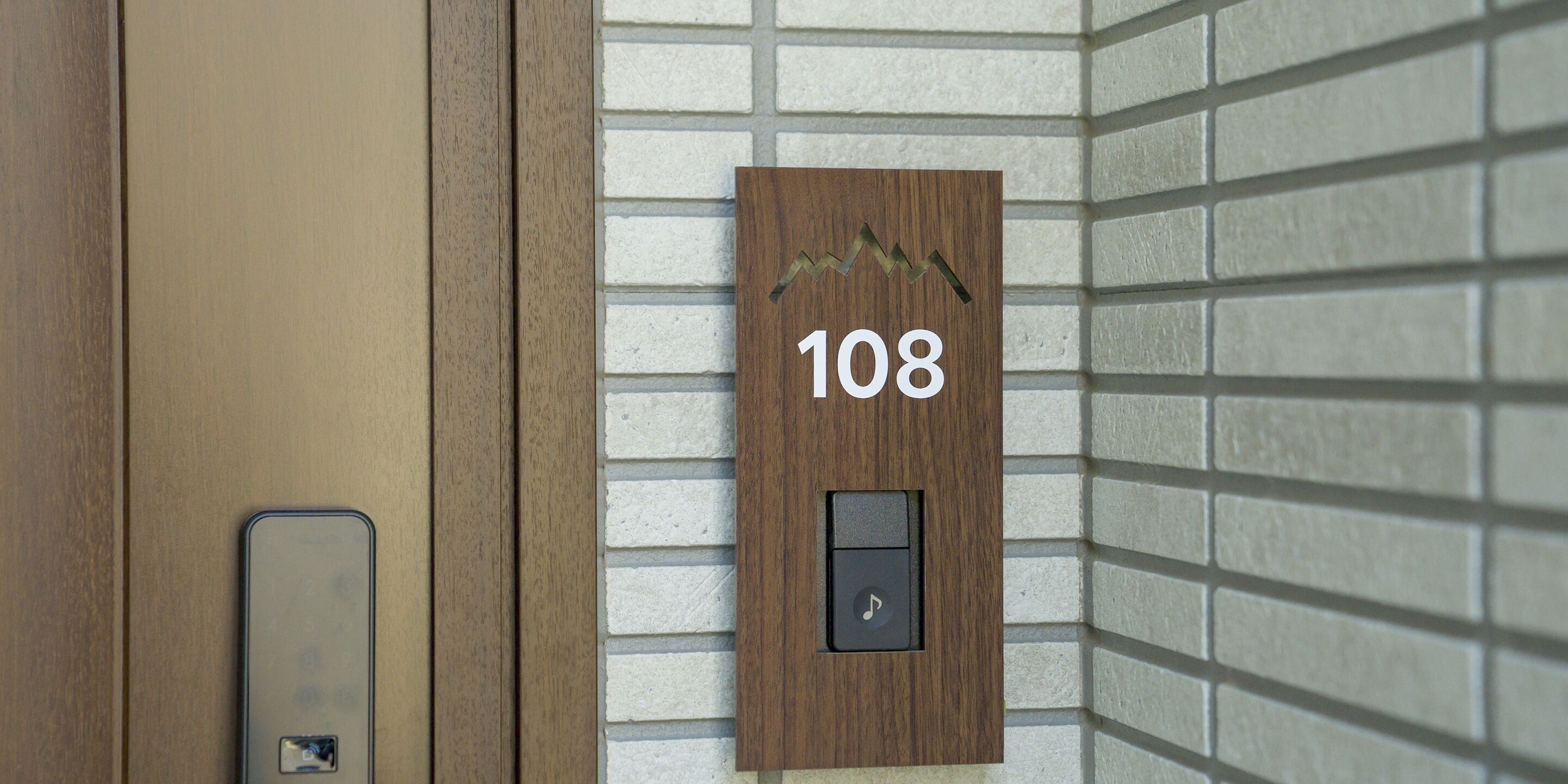 A wooden wall-mounted sign with the number 108, indicating a room or apartment number.