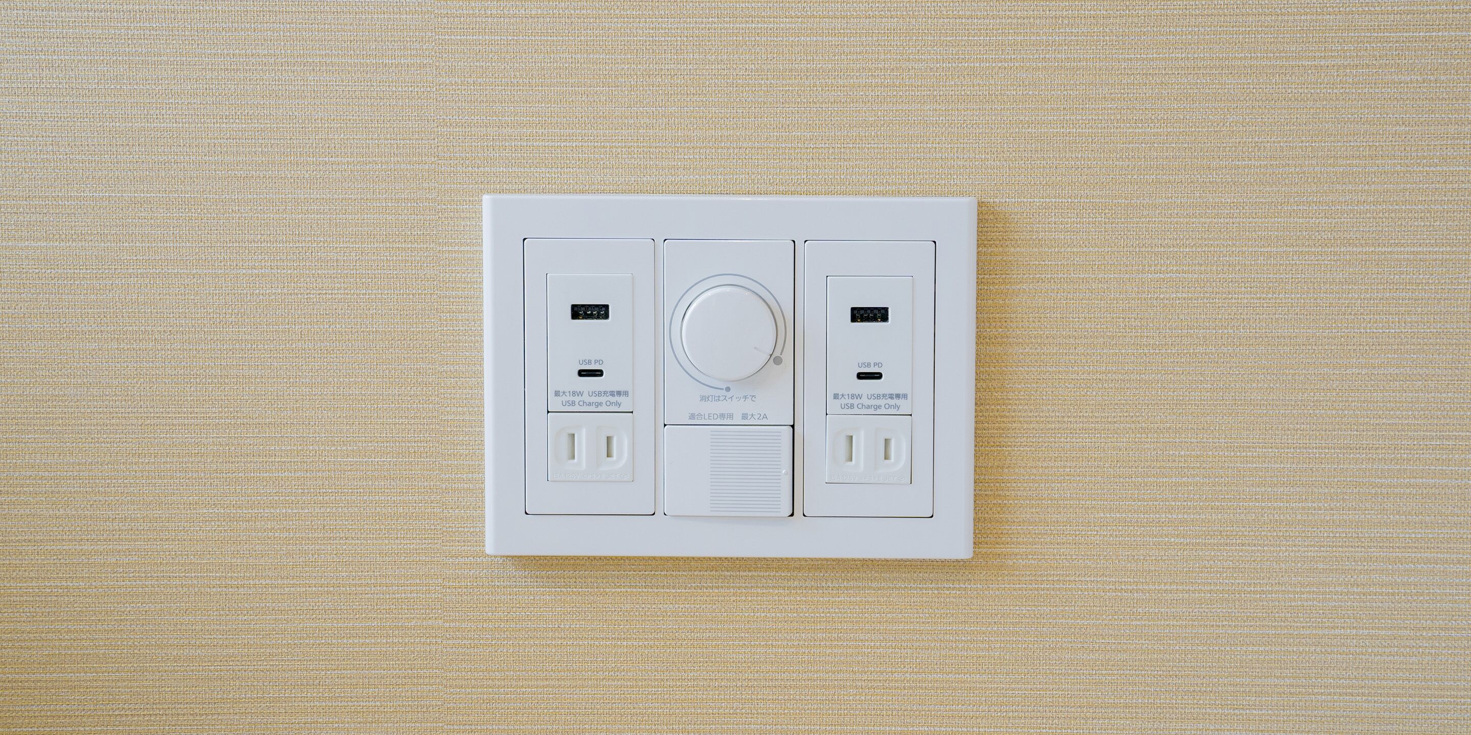 A white electrical panel with two USB PD ports and a circular dial, likely for controlling lighting or power.