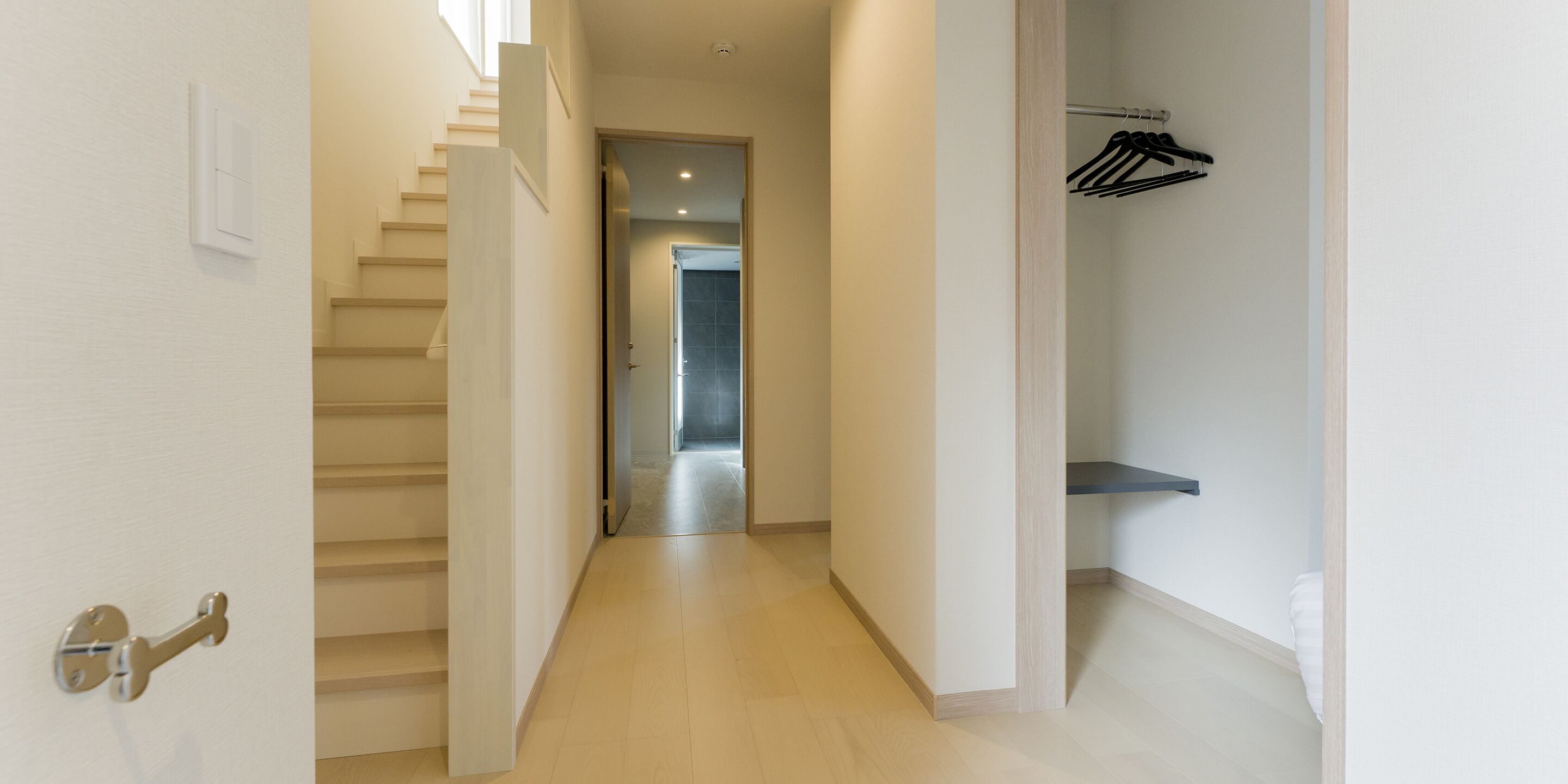 Un pasillo con una escalera que lleva a un baño.