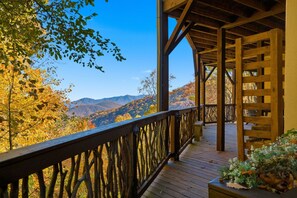A wooden deck with a railing, overlooking a mountainous landscape with autumn foliage. - Amazing Mountain Views Black Mountain Asheville Cabin (Black Mountain)