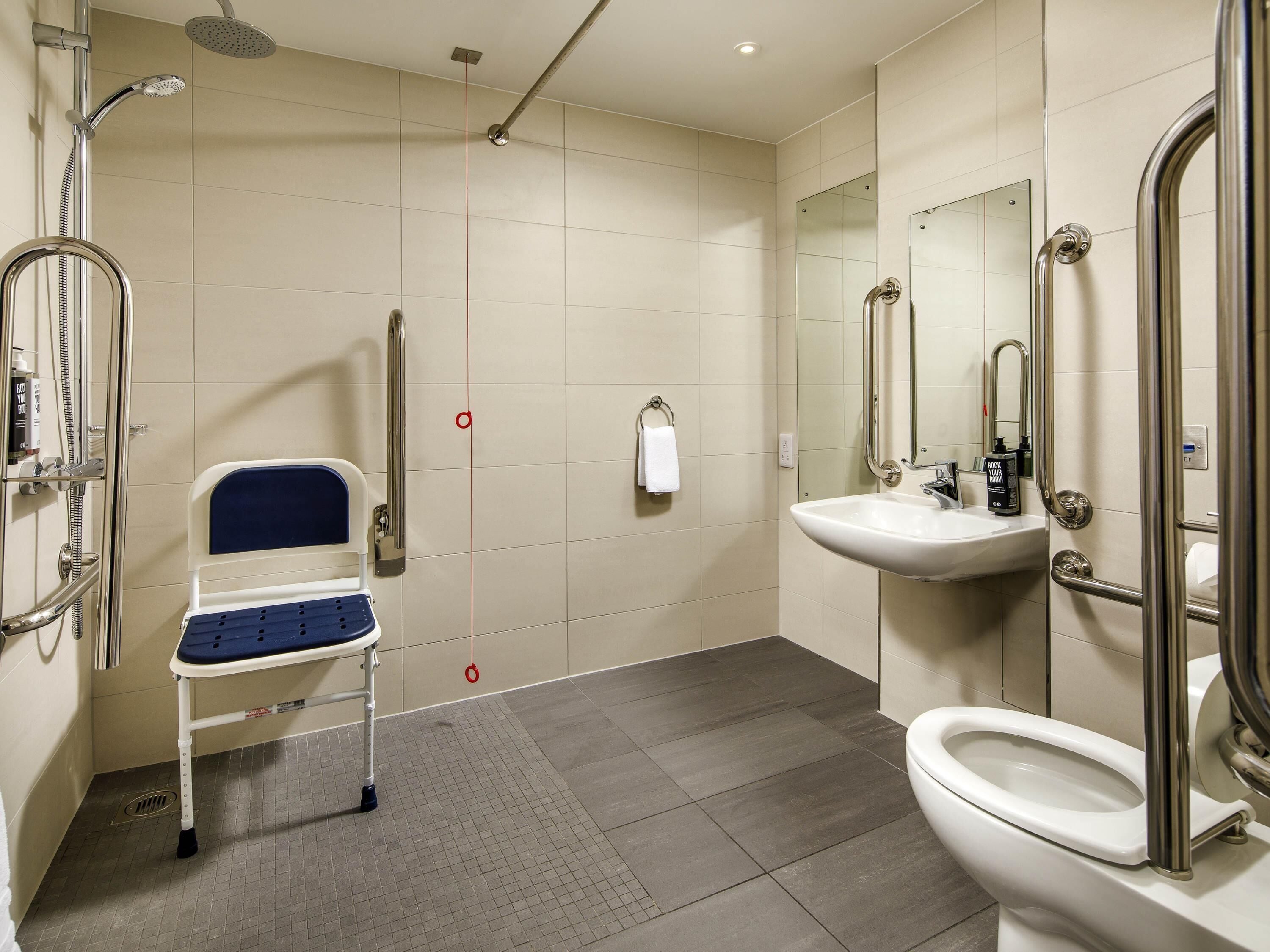 A modern bathroom with a shower, toilet, and sink.