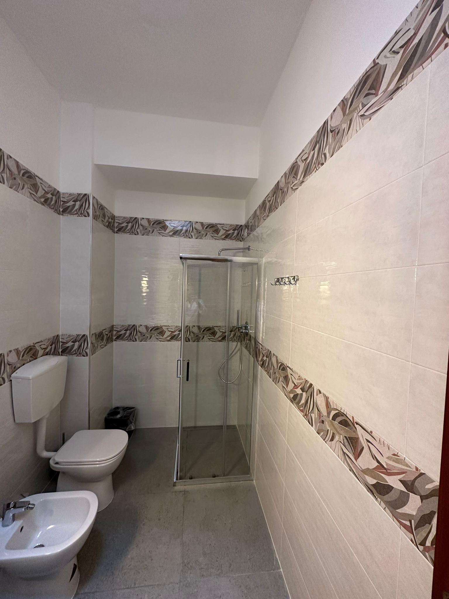 A bathroom with a toilet, bidet, and shower stall.
