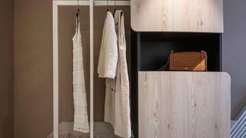 Una habitación con un armario de madera, una percha y un bolso en la estantería.