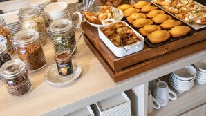 A buffet with various food items, including cookies, pastries, and a dish with a white sauce. - Ibis Styles Porto Vecchio (Porto-Vecchio)