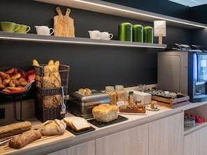 Un ricco buffet per la colazione con pane, dolci e salse.