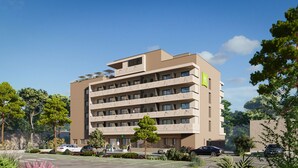 A multi-story hotel with a flat roof, balconies, and a sign indicating it is part of the ibis group. - Ibis Styles Porto Vecchio (Porto-Vecchio)