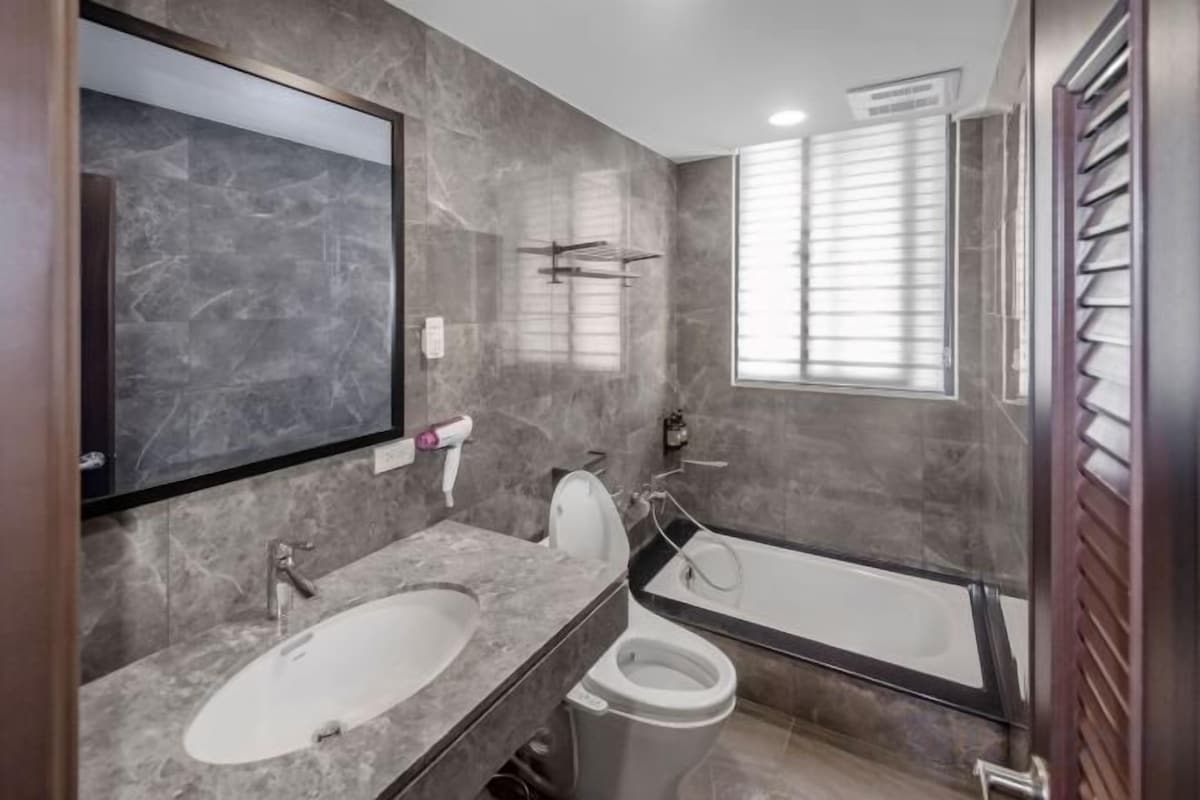 A bathroom with a marble sink, toilet, and bathtub.