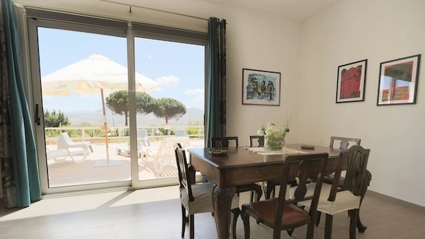 A dining area with a table and chairs, a view of the outdoors, and artwork on the wall. - Villa NELLA, relax and amazing view (Sicilia)