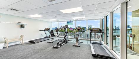 A gym with treadmills, elliptical machines, and a bench.