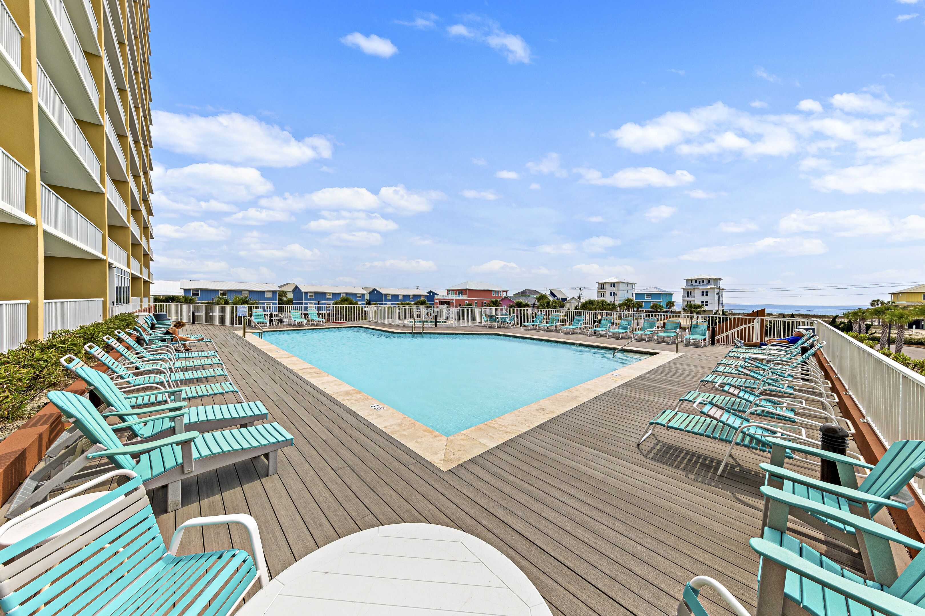 A poolside area with lounge chairs and a pool.