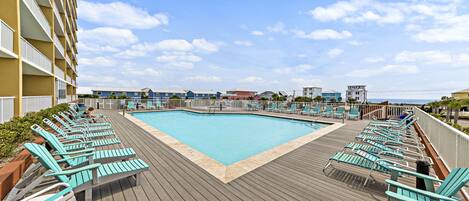 A poolside area with lounge chairs and a pool.