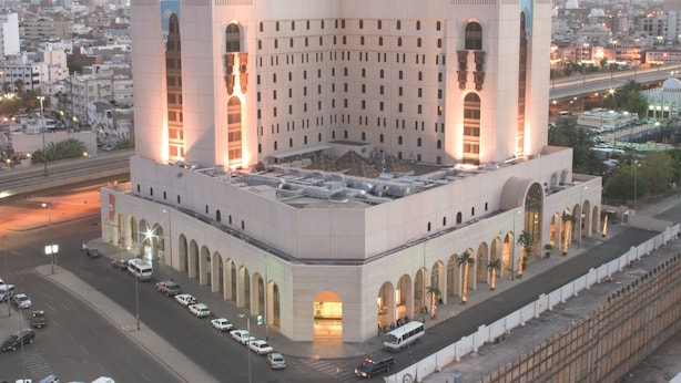 A large, modern building with a central courtyard, surrounded by a cityscape. - New Madinah Hotel (Madinah)