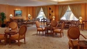 A spacious lobby with a large sofa set, multiple armchairs, a coffee table, and a small dining table. - New Madinah Hotel (Madinah)