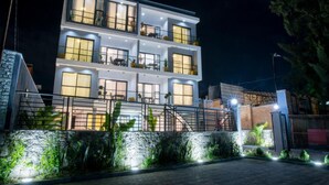 A multi-story hotel with balconies, large windows, and a stone facade. - Rose Aparthotel (Kigali)