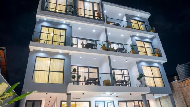 A multi-story hotel with a reception on the ground floor, balconies on each floor, and large windows. - Rose Aparthotel (Kigali)