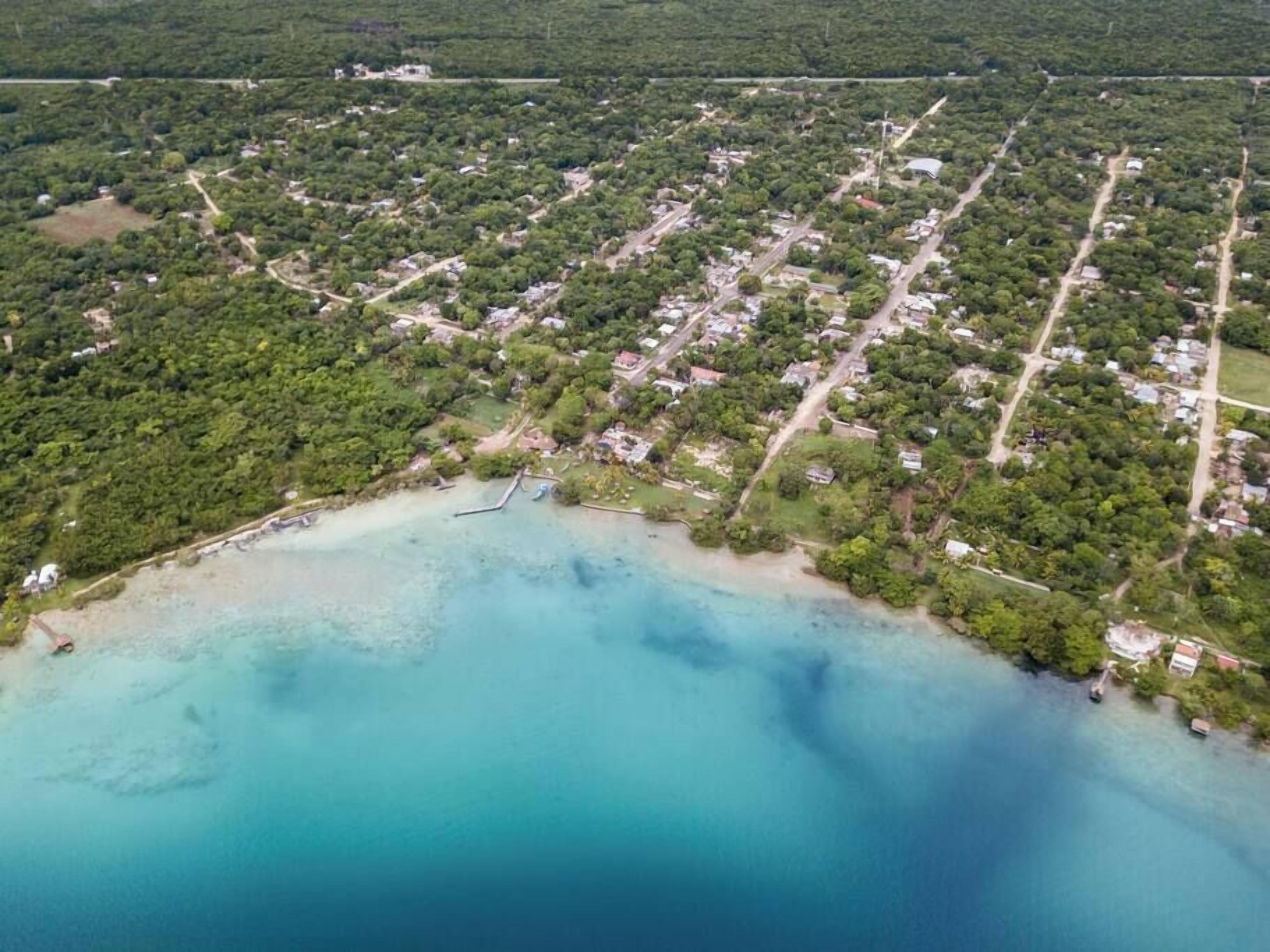 Vista aérea de una zona costera con edificios residenciales, carreteras y una playa.
