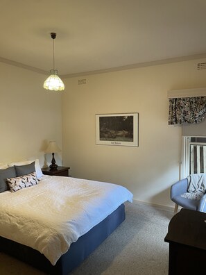 Relax in this serene bedroom with a large bed, bedside table, and a beautiful forest view.