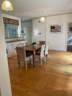 Enjoy meals in this cozy dining area with a wooden table and wicker chairs.