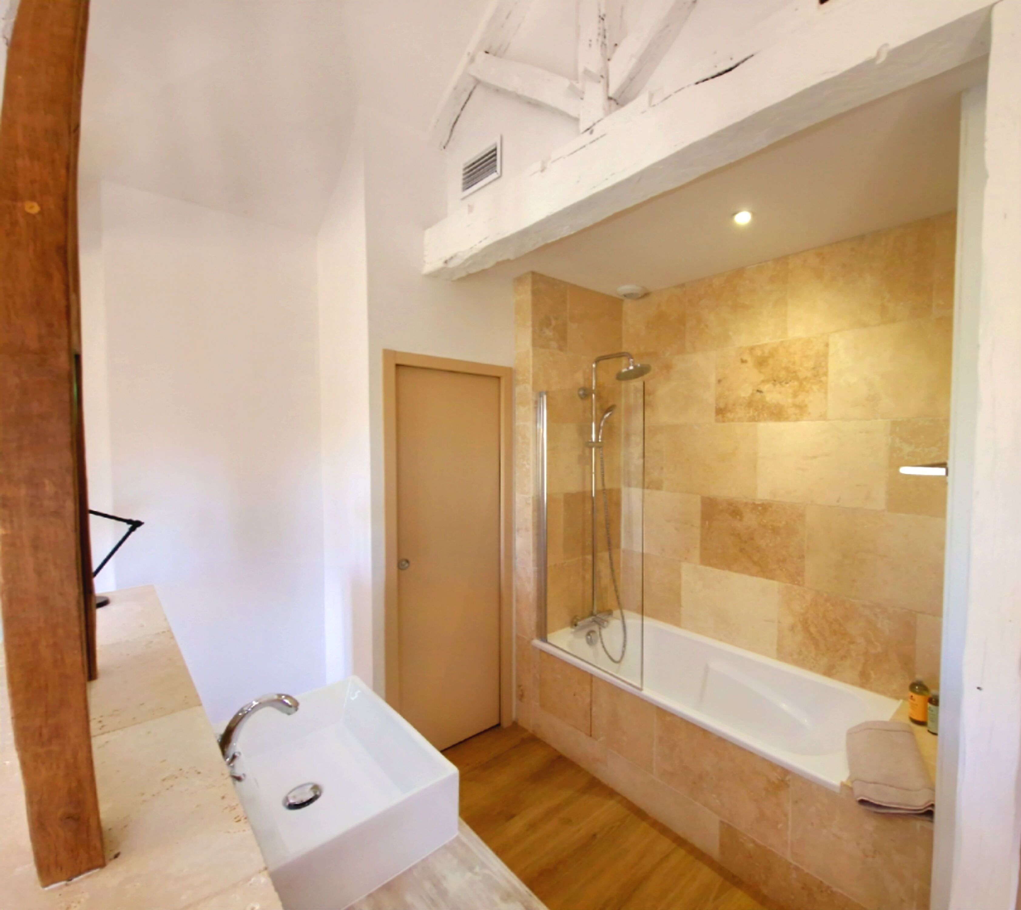 Un baño moderno con ducha de vidrio, lavamanos independiente y bañera.