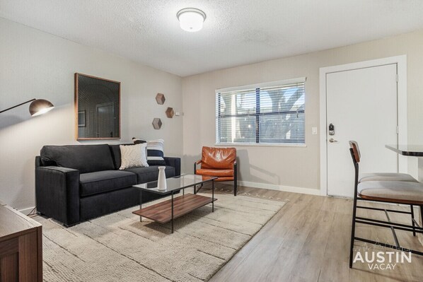 A modern living room with a sofa, coffee table, and a leather chair.