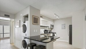 A modern kitchen with a central island, built-in appliances, and a large window. - Chelsea #250 xxxxxxx (Austin)