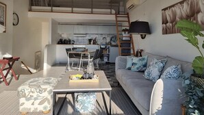 Eine moderne Wohnung mit Schlafgalerie, Essbereich und Wohnzimmer.