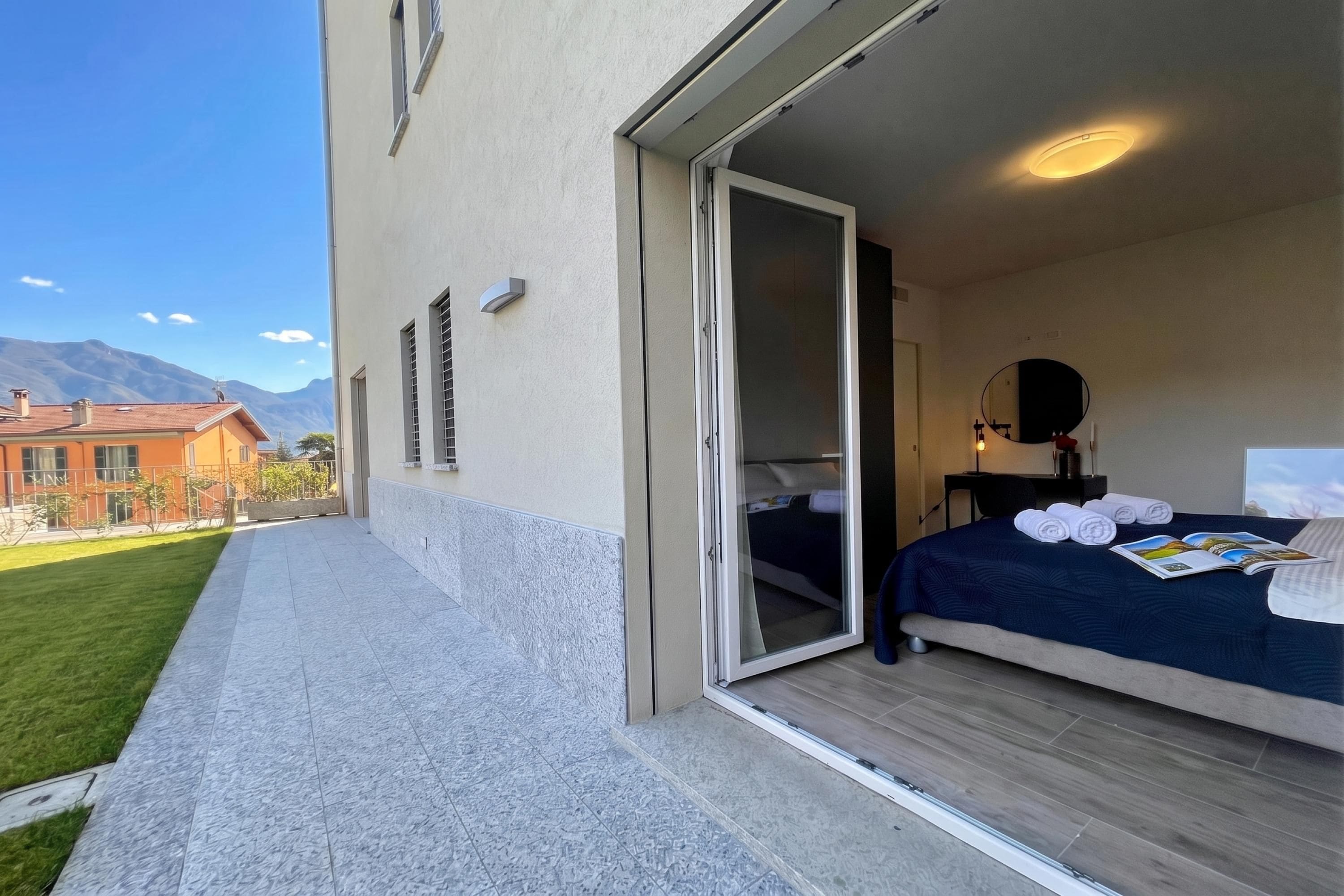 A hotel room with a bed, a bathroom, and a sliding glass door leading to a balcony.