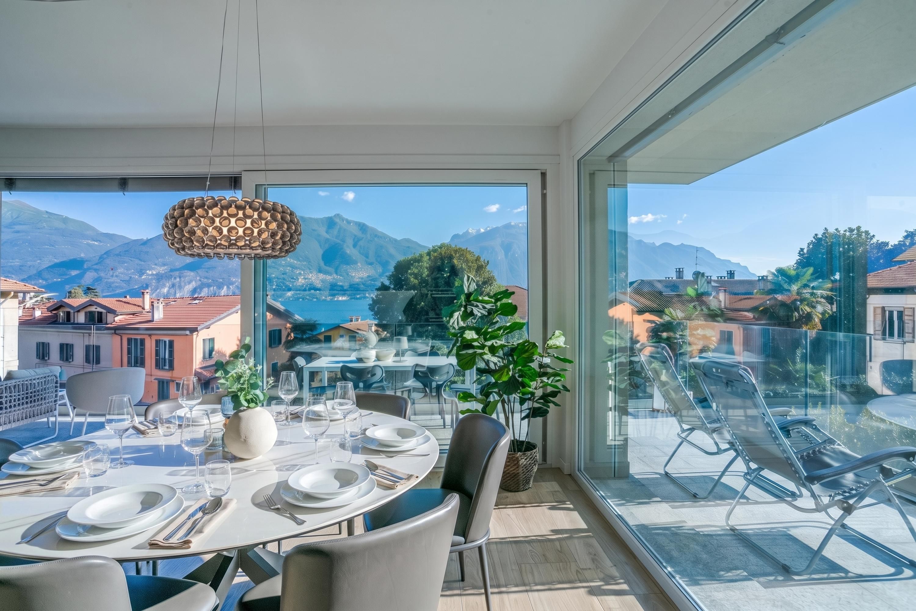 A dining area with a table set for four, overlooking a mountainous landscape.