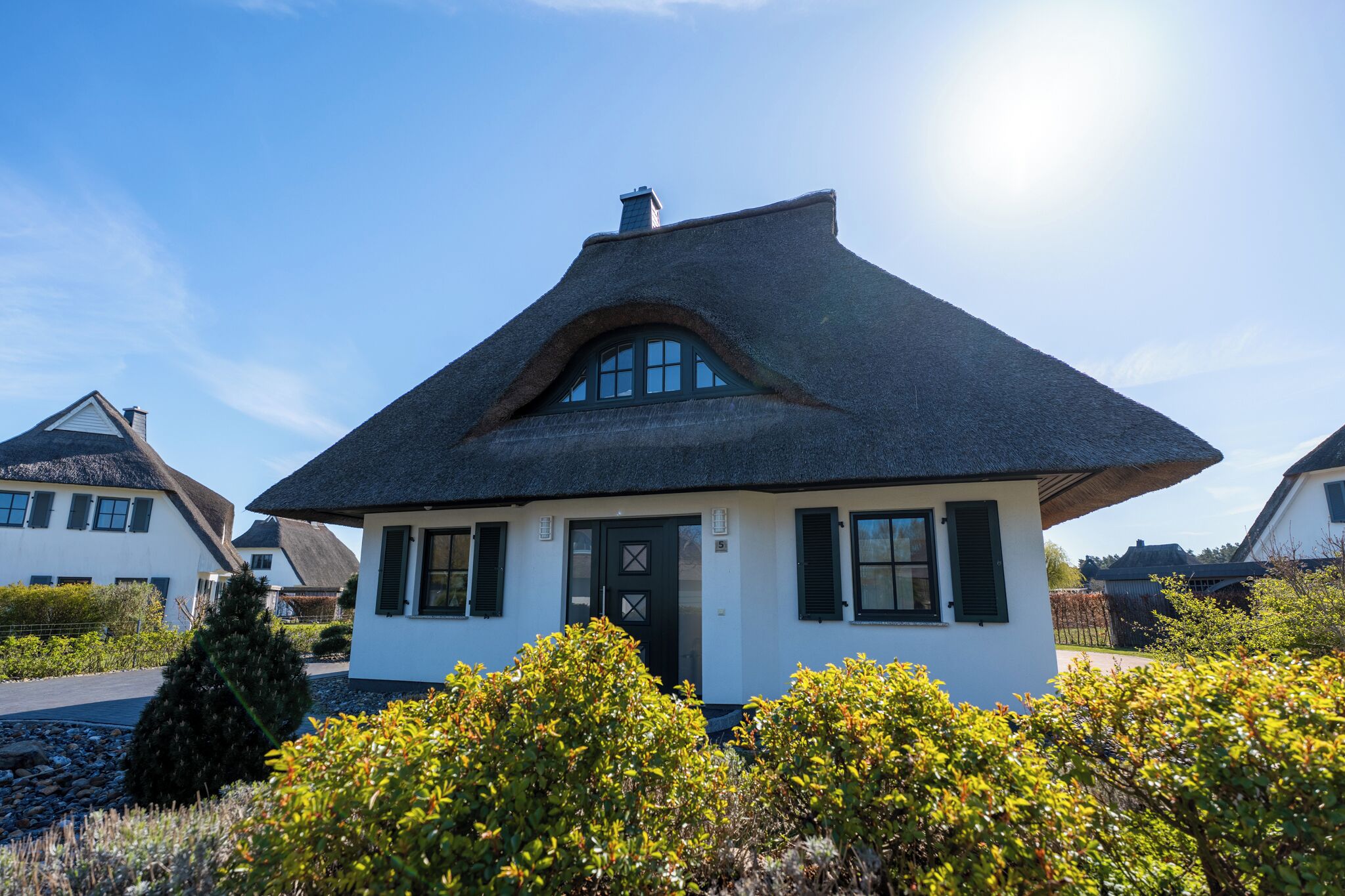 A house with a steeply pitched roof, a front door with a cross-shaped window, and a small porch.