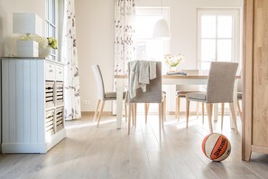 Un coin repas comprenant une table, des chaises, un buffet et un ballon de basket sur le sol.
