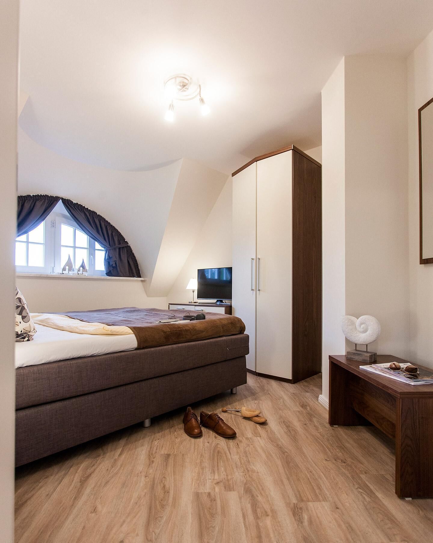 Un dormitorio con cama, armario, escritorio y televisor.