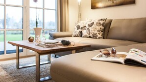 Ein modernes Wohnzimmer mit einer Couch, einem Couchtisch und einem Bücherregal.