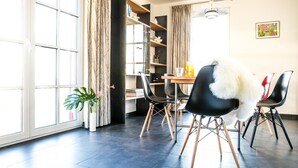 Un comedor moderno con una mesa, sillas y una planta en maceta.