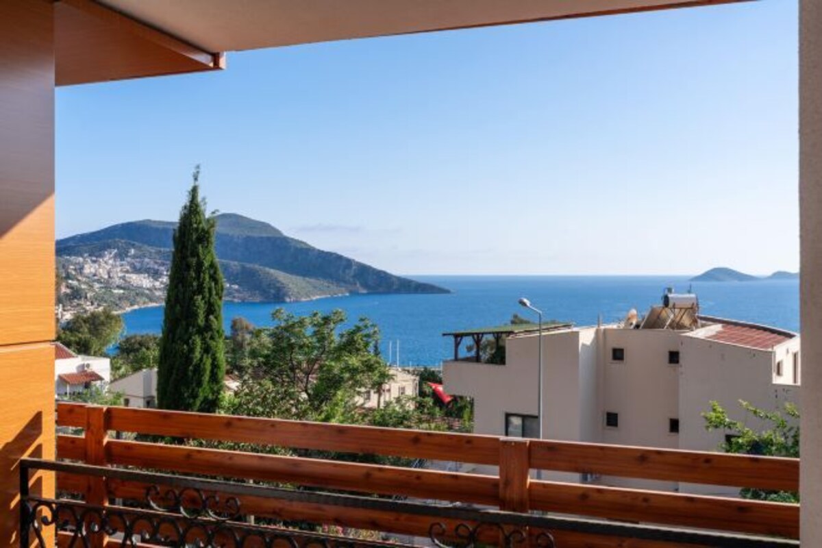 Un balcón con vista al mar y a las montañas.