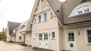 Eine Reihe moderner Häuser mit einheitlichem Baustil, erkennbar an ihren Satteldächern und weißen Türen.