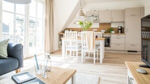 Ein modernes Apartment mit Essbereich, Küche und Wohnzimmer.