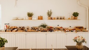 A buffet setup with various food items and plants on shelves. - Bayit Charming Place (Polignano a Mare)