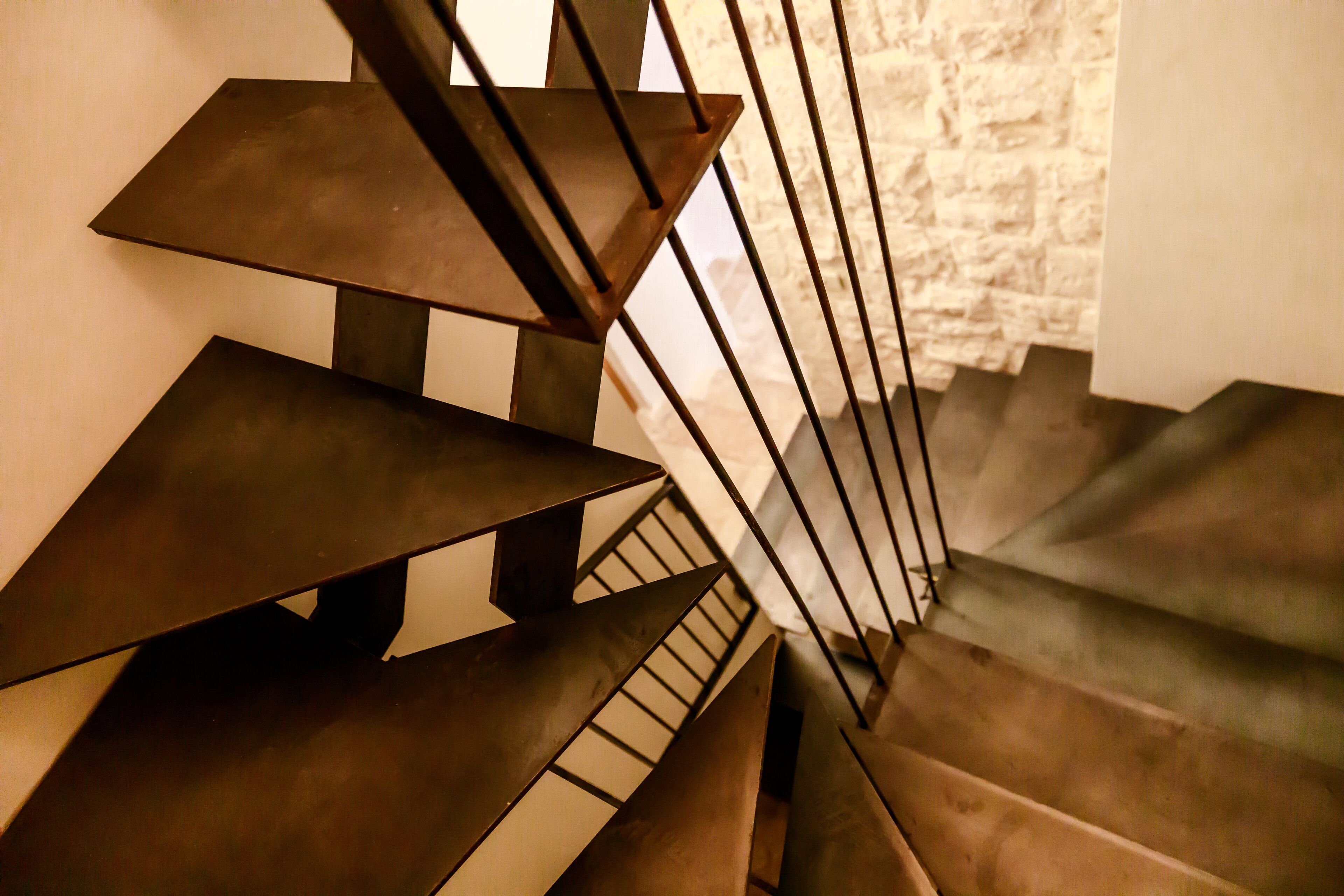 Una escalera con un diseño geométrico y barandillas de metal.